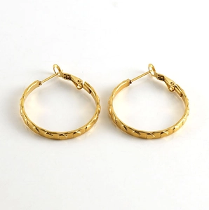 Dettaglio orecchini a cerchio placcati oro 18k con texture a cuore in rilievo lucido