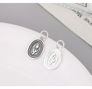 Detailed view of oval tulip pendants in vintage black and polished silver finishes