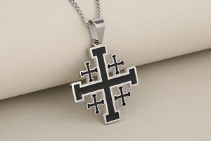 Macro detail of silver stainless steel Jerusalem cross pendant with black enamel inlay