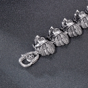Macro view of vintage silver warrior skull and feather links on a steel bracelet