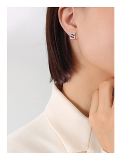 Gros plan de boucles d'oreilles carrées avec motif cerise rouge sur un mannequin