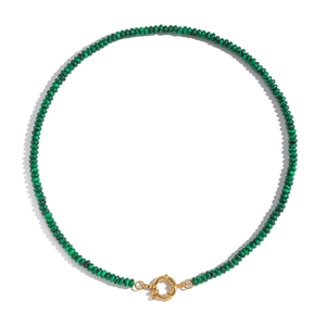 Macro shot of green stone beads necklace with gold round clasp on white backdrop