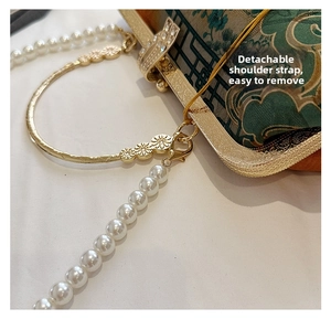 Detail of the green floral shell bag showing the detachable white pearl chain strap