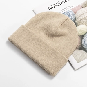 Detail of oatmeal ribbed knit beanie featuring soft texture and stylish folded cuff