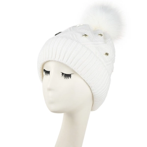 Women's white winter knit beanie with soft faux fur pom and golden metal cone studs