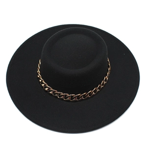 Detailed close-up of a black flat top wool felt hat featuring a bold gold chain band detail