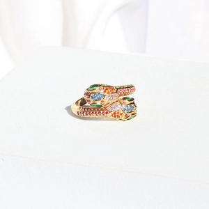 Macro detail of golden double-headed snake ring with colorful zircon pave stones