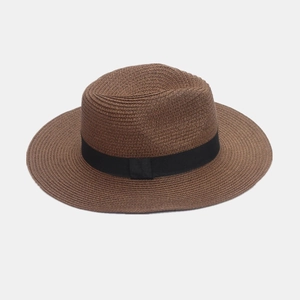 Close-up of brown straw Panama hat with black ribbon detail and fine woven texture