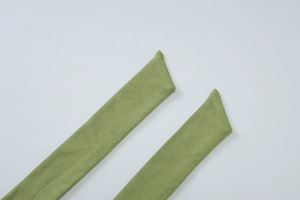 Detail shot of the green ribbed knit waist tie straps with elegant diagonal cut ends