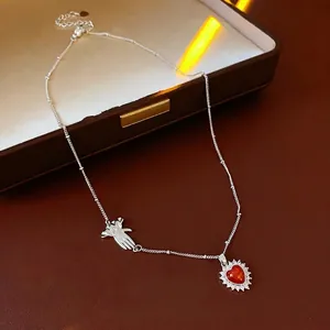 Vintage silver heart pendant necklace with zircon border and palm charm on leather backdrop