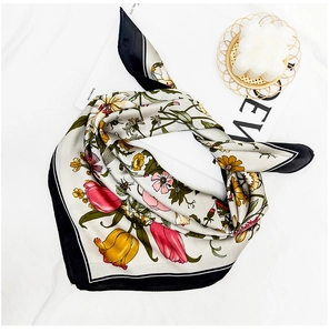 Macro detail of silk square scarf with floral tulip patterns and black contrast borders