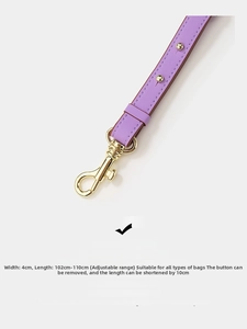 Close-up of adjustable purple leather bag strap with gold metal buckle and rivets
