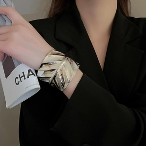 Détail du bracelet argenté à texture ondulée irrégulière et effet métallique froissé