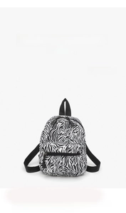 Close-up of zebra pattern mini canvas backpack featuring a front pocket and top handle