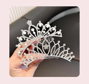 Detail of silver crown hair comb featuring sparkling rhinestones and white pearls decoration