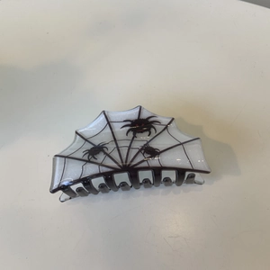 Detail of Halloween hair claw clip with spider and web patterns in black and white