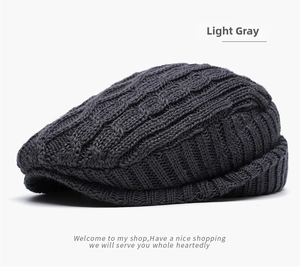 Detailed view of dark gray knit beret with classic cable stitch patterns for winter warmth