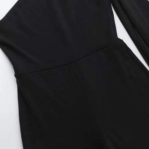 Détail des coutures et de la taille d'une combinaison asymétrique en tissu noir extensible