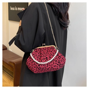 Detail of fuchsia leopard print shell bag with pearl handle and gold chain strap