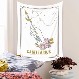 Bohemian Sagittarius zodiac tapestry featuring roses and gold stars on a white wall
