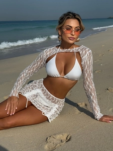 Dettaglio macro del tessuto in pizzo floreale bianco di un bikini da spiaggia boho
