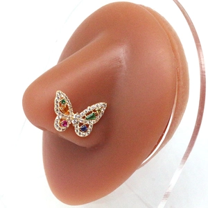 Clou de nez papillon doré avec cristaux colorés présenté sur un modèle de nez en silicone