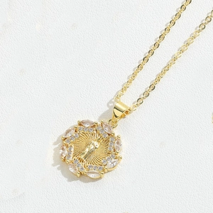 Macro shot of gold-plated pendant with sparkling zircon insets and religious figure detail