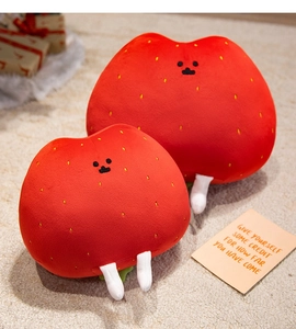 Macro detail of strawberry plush toys with embroidered seeds on soft fabric