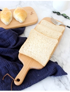 Japanese beech wood cutting board with leather lanyard on marble surface