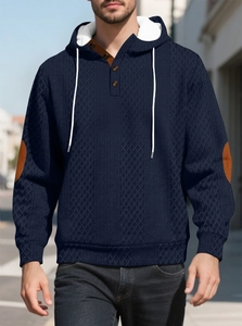 Détail du sweat à capuche marine avec tissu texturé et coudières en cuir marron