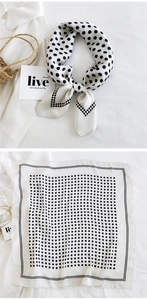 Detailed view of white silk scarf with black polka dots and decorative dashed border