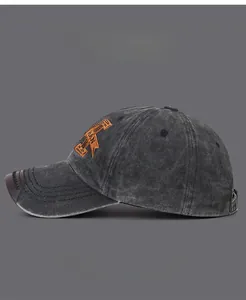 Detail view of washed grey baseball cap with orange 3D embroidered A and leather trim