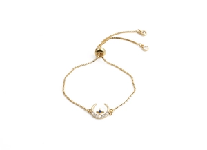 Detail of gold box chain bracelet with crescent moon and blue star zircon charms