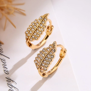Elegant gold leaf earrings with sparkling white cubic zirconia on white background