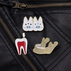 Detail showing cartoon dental enamel pins on black leather jacket texture