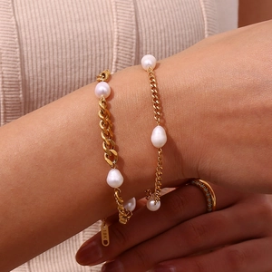 Macro shot of 18K gold stamped clasp and baroque pearls on a stainless steel bracelet