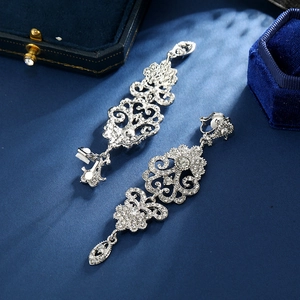 Vintage silver hollow-out long pendant clip earrings with crystals on dark velvet