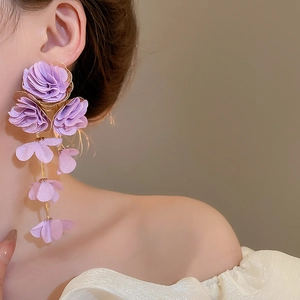 Close-up of elegant purple chiffon flower tassel earrings worn by a model