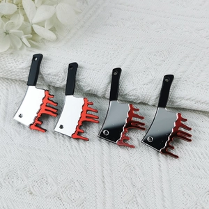 Macro detail of acrylic Halloween meat cleaver charms with realistic red blood drip effects