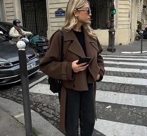 Détail du manteau ample en laine marron foncé avec revers et ceinture assortie assortie