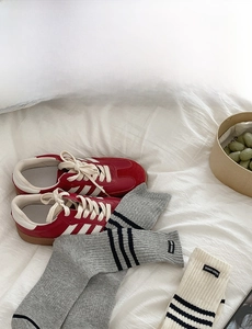 Detailed texture of grey and beige ribbed cotton socks with black stripes and label