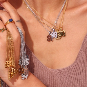 Detailed view of 18K gold and silver year number pendants on classic link chains