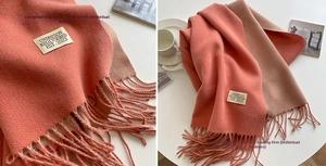 Detail of pink and beige double-sided cashmere scarf with fringe and fabric label
