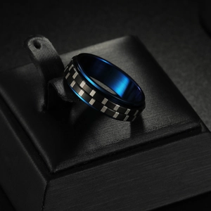 Detail of 6mm black and blue spinner ring with brushed texture on leather display stand