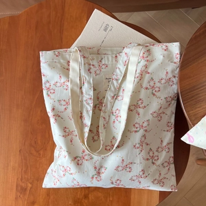Détail d'un sac cabas en toile à fleurs montrant l'étiquette intérieure et les coutures