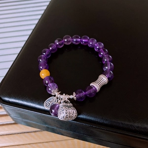 Detailed macro view of S925 silver amethyst bracelet with retro money bag pendant