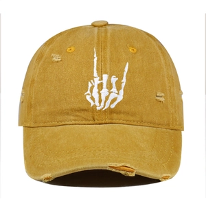Detail of white skeleton hand embroidery on a distressed ginger cotton baseball cap