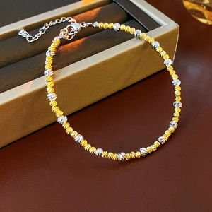 Detail of two-tone gold and silver beaded bracelet with lobster clasp in a jewelry box