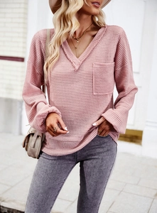 Detailed shot of pink waffle knit V-neck top featuring a chest pocket and soft texture