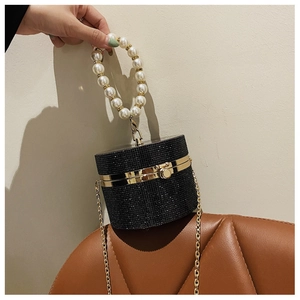 Detailed view of luxury black rhinestone cylinder handbag with pearl handle and gold chain